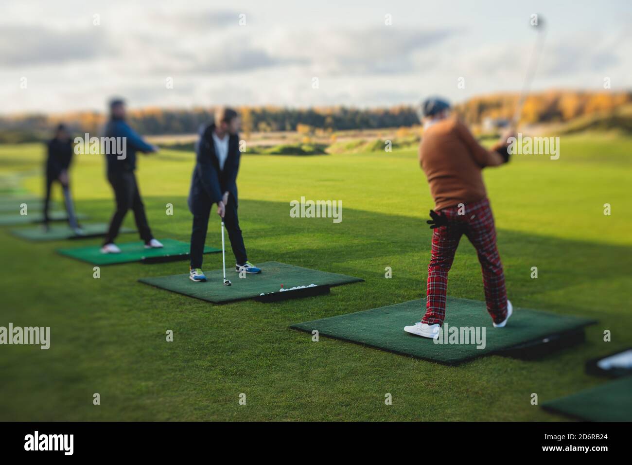 Group of golfers practicing and training golf swing on driving range  practice, men playing on golf course, golf ball at golfing complex club  resort, s Stock Photo - Alamy