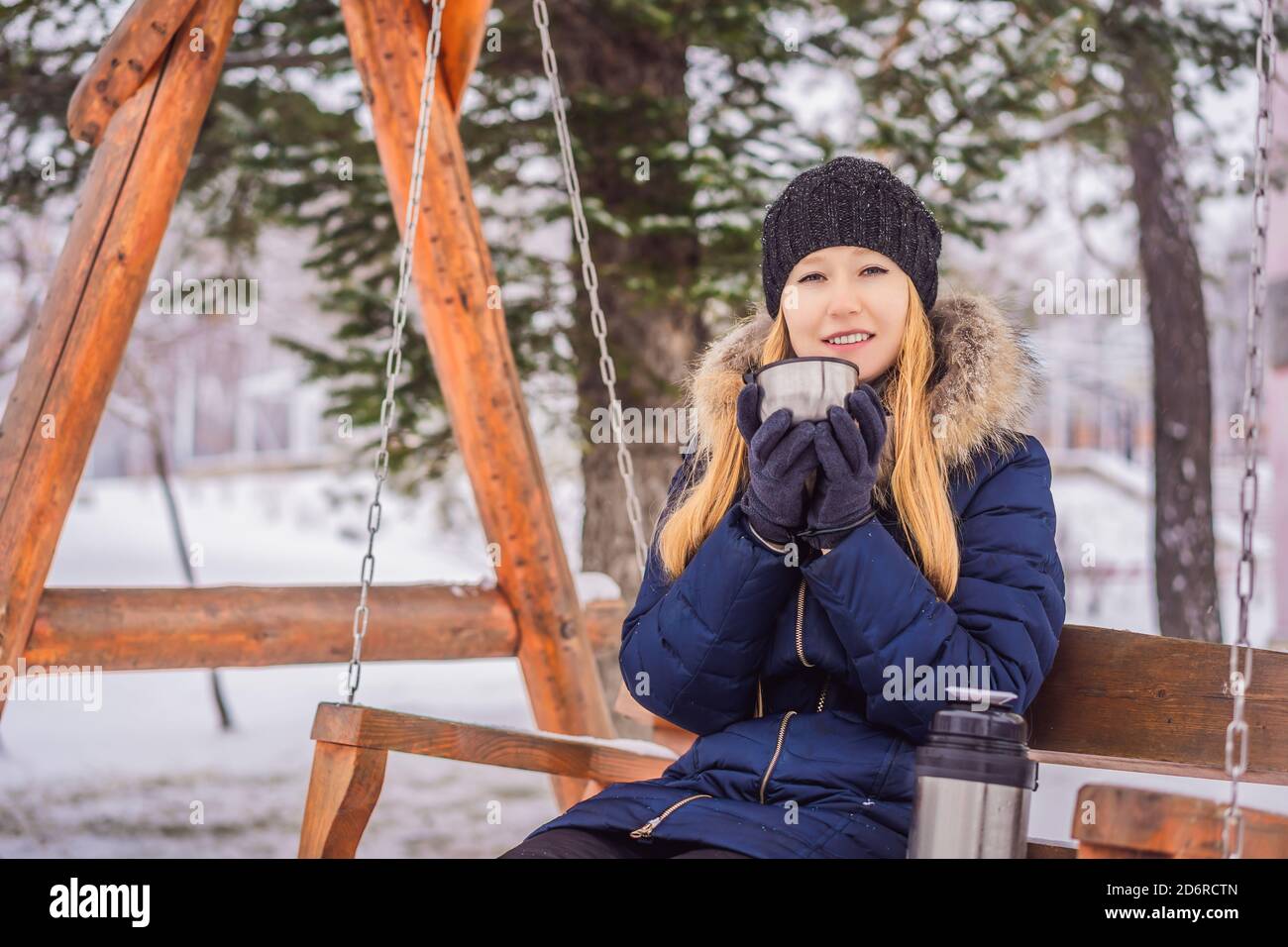 Woman drinks tea from a thermos on a winter day Stock Photo