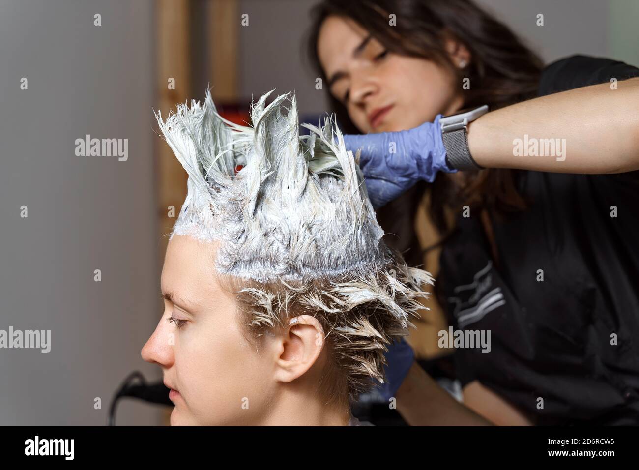 hair dyeing process with foil. beautiful woman hairdresser in the process of dyeing hair to the client using foil Stock Photo