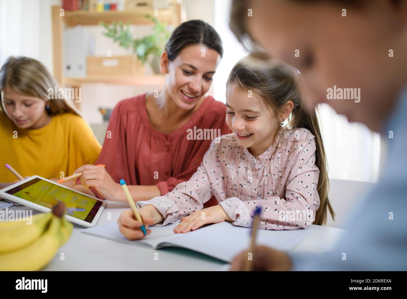Group of homeschooling children with teacher studying indoors, coronavirus concept. Stock Photo