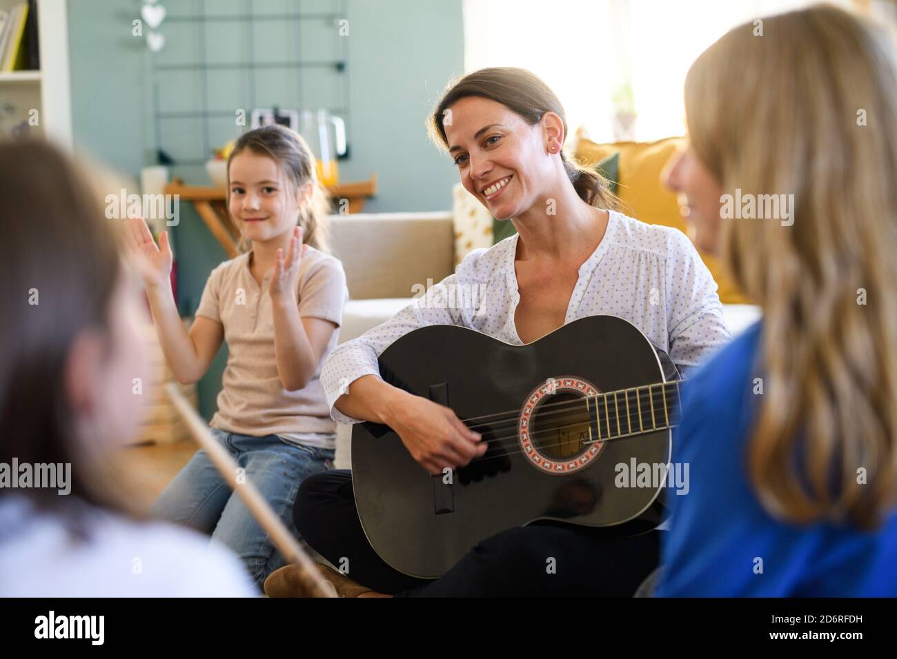 Group of homeschooling children with teacher having music lesson indoors, coronavirus concept. Stock Photo
