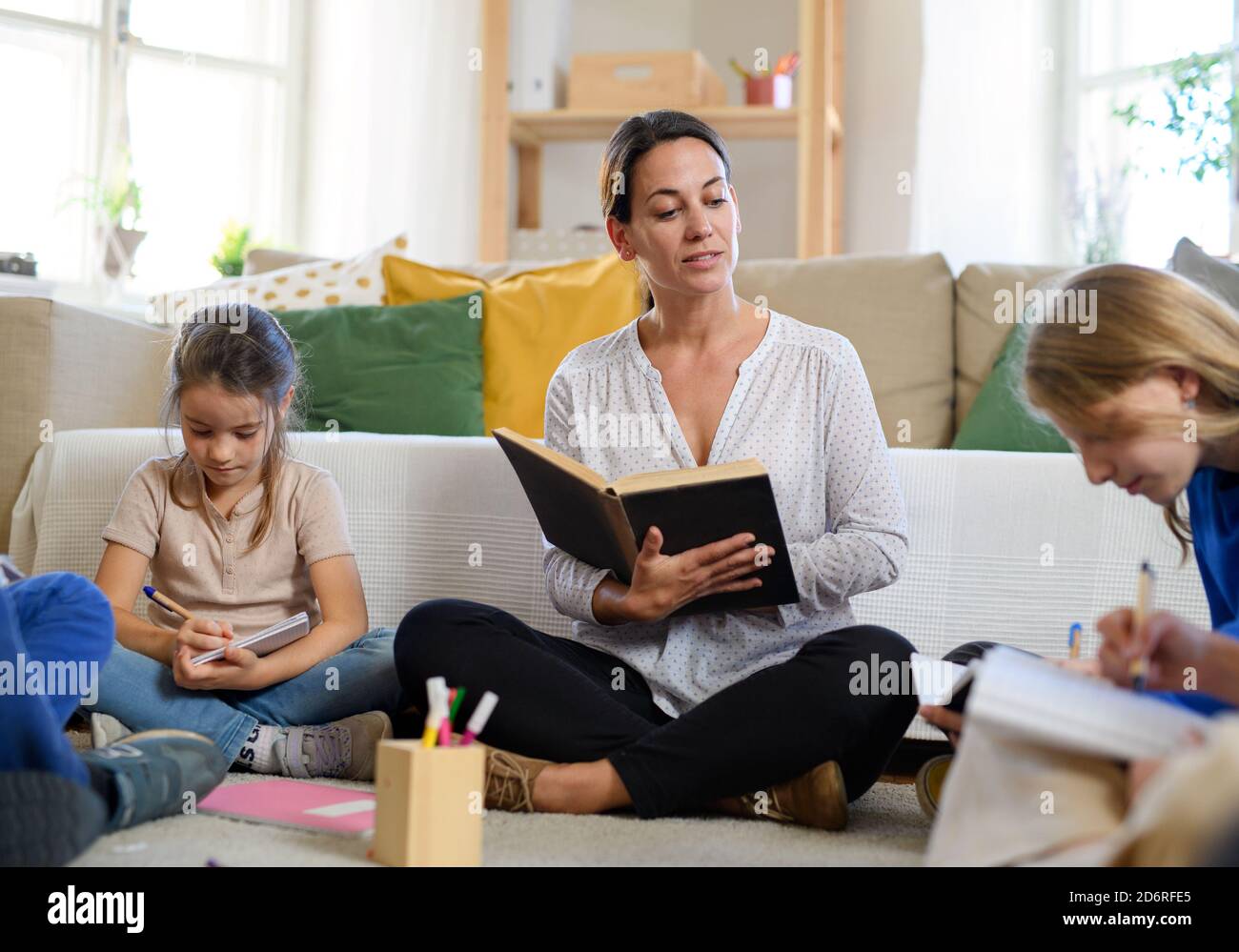 Group of homeschooling children with teacher studying indoors, coronavirus concept. Stock Photo