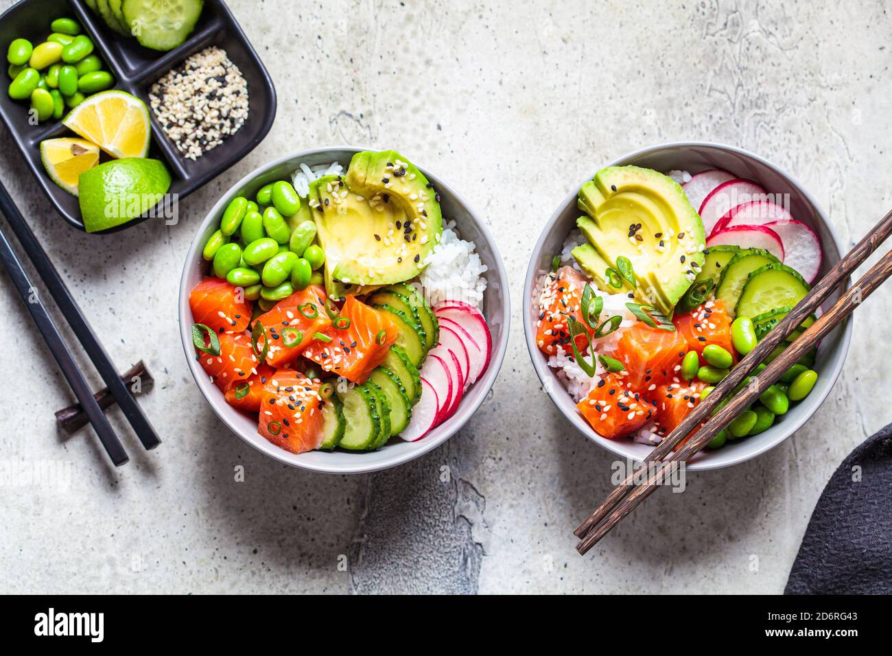 Poke bowl with salmon, rice, avocado, edamame beans, cucumber and radish in a gray bowl