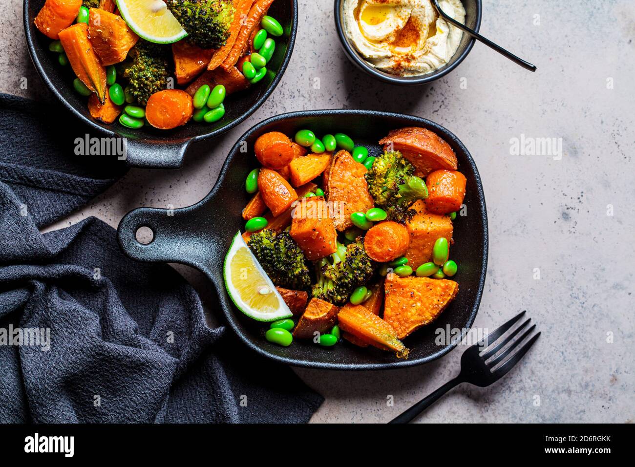 Baked vegetables in cast iron pans, dark background. Baked sweet