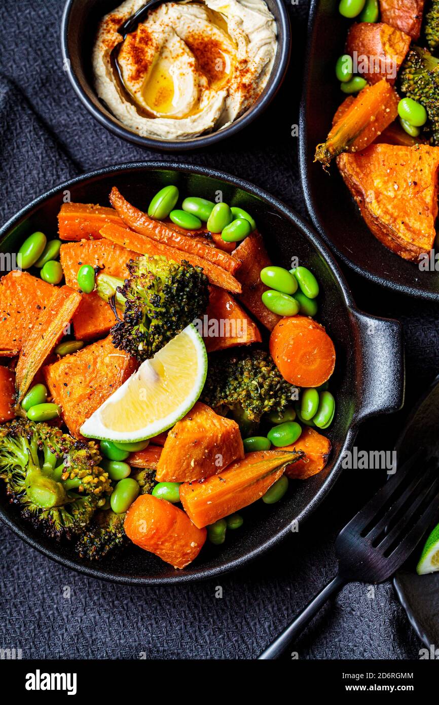 Baked vegetables in cast iron pans, dark background. Baked sweet