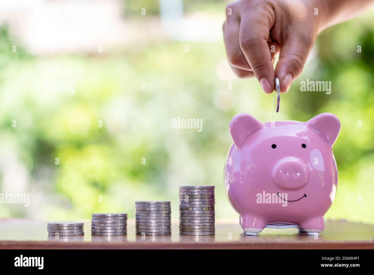Putting a coin into a piggy bank hi-res stock photography and images ...