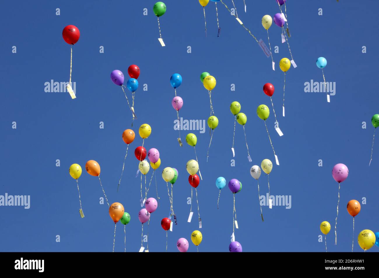 Annbank, South Ayrshire, Scotland, UK. Local primary school release balloons against a clear blue sky Stock Photo