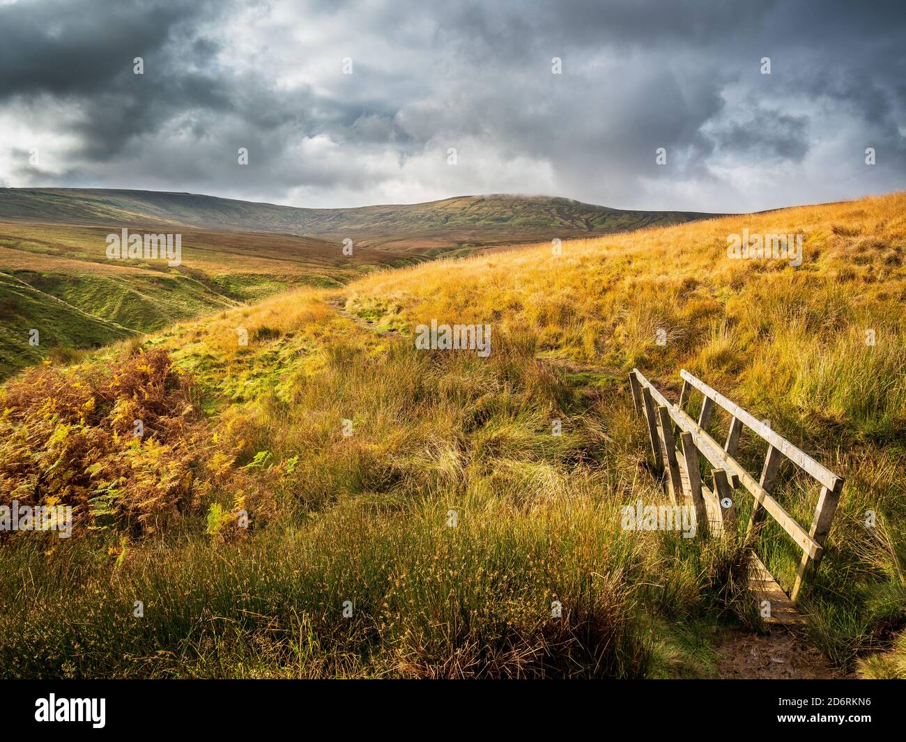 Open moorland with the view towards Little Whernside with wooden footbridge. Yorkshire Dales Stock Photo