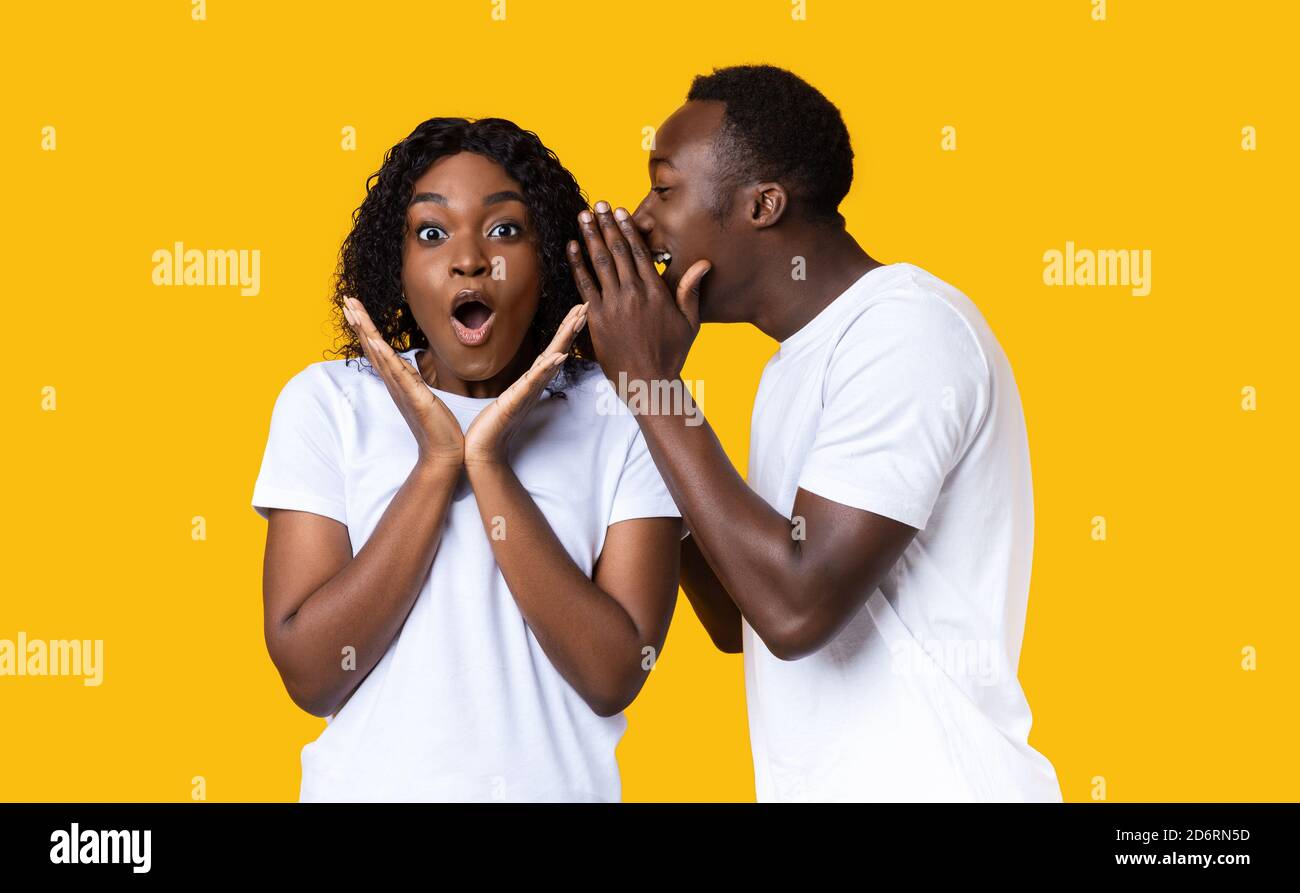 Black guy sharing secret with his amazed girlfriend Stoc photo