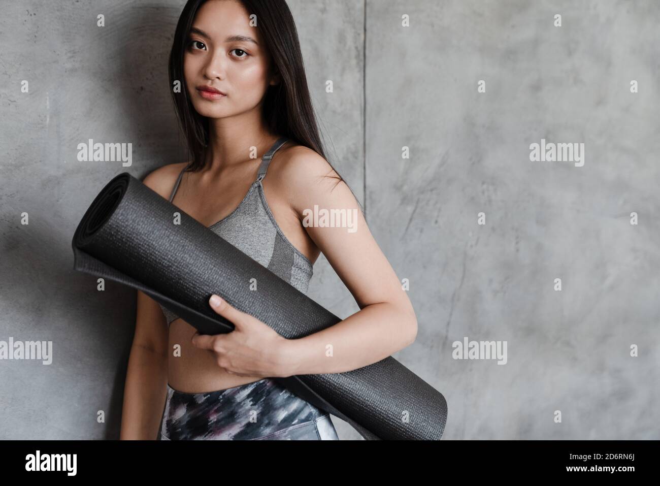 Image of beautiful asian girl in sportswear posing with yoga mat at ...
