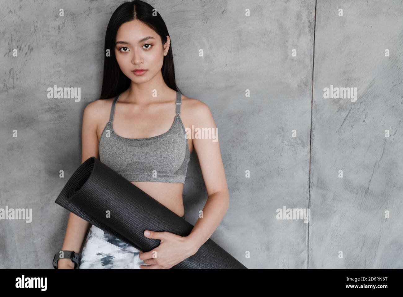 Image of beautiful asian girl in sportswear posing with yoga mat at ...