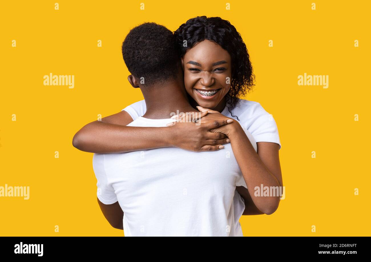 Emotional black woman hugging her boyfriend and smiling at camera Stock ...
