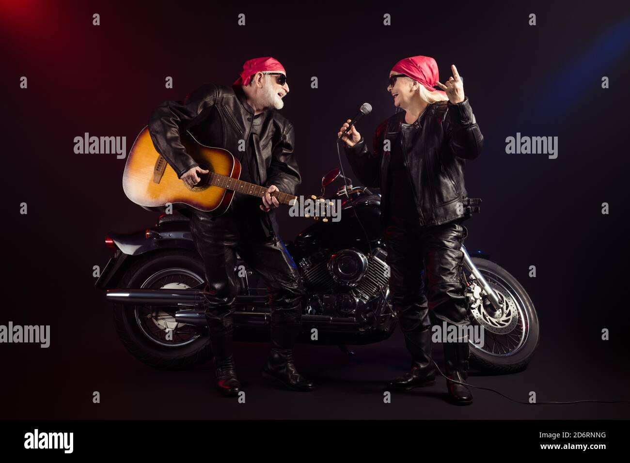 Full body photo of aged cool bikers man lady couple chopper moto rock festival play guitar sing famous hit show horns wear trendy rocker leather Stock Photo