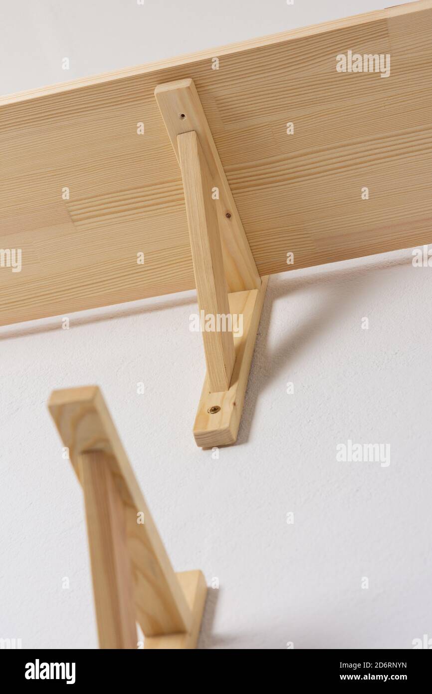 The process of attaching a wooden shelf to the wall, shelf corners