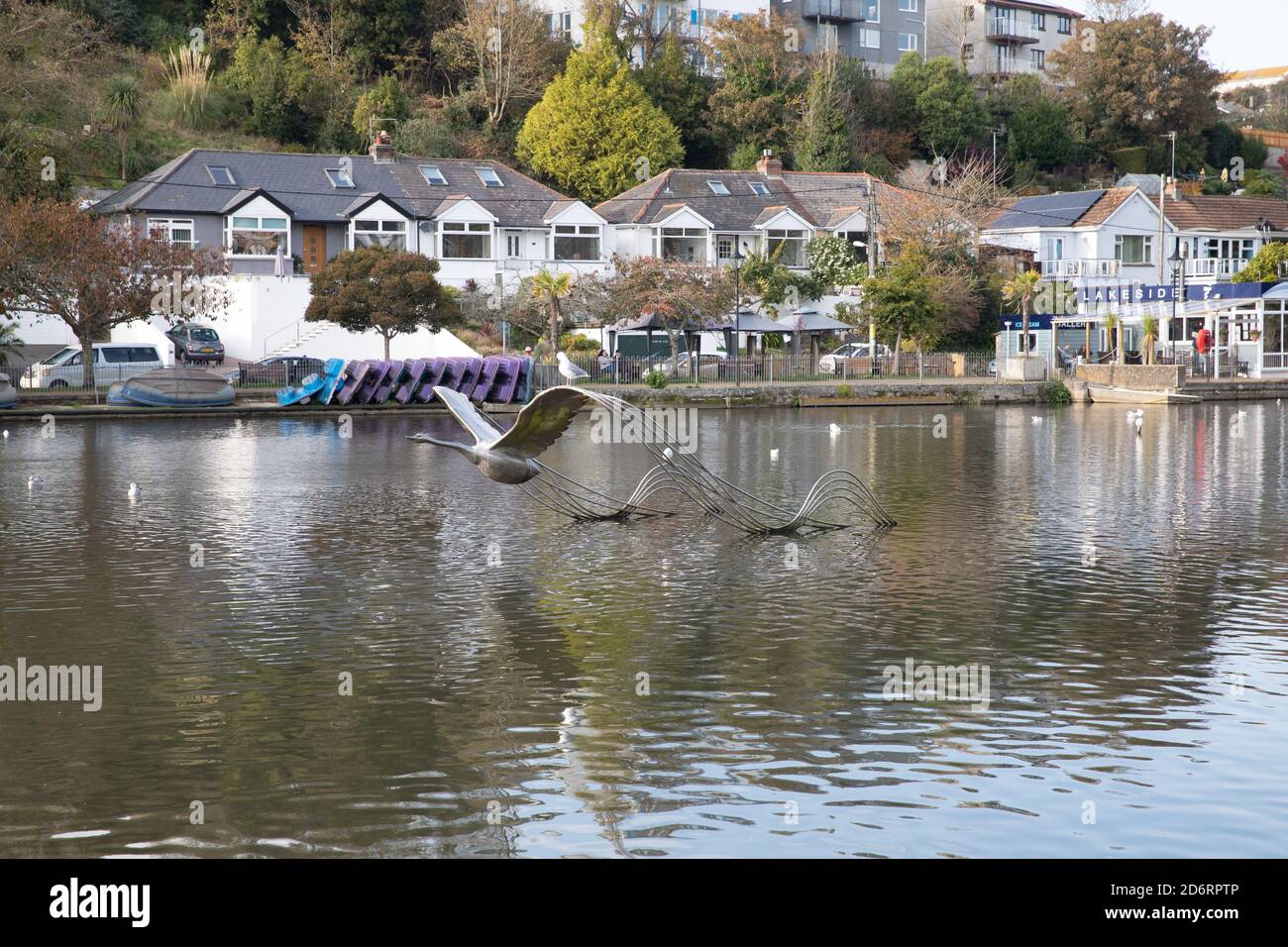 Swan taking off metal sculpture in the middle of the lake in Trenance gardens, Newquay, Cornwall Stock Photo