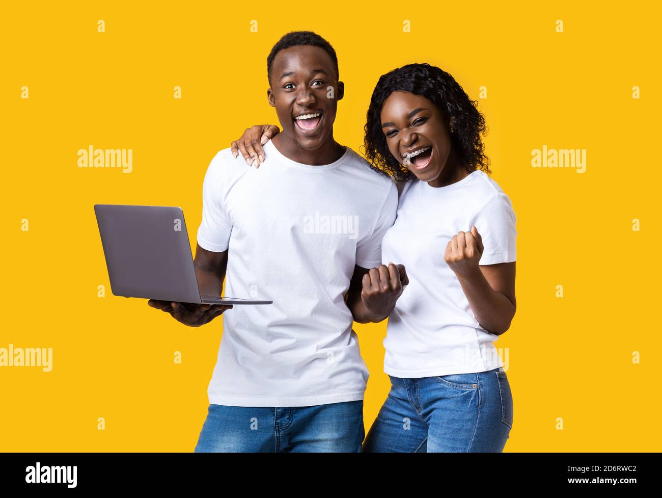 Excited black couple celebrating win with laptop Stock Photo - Alamy
