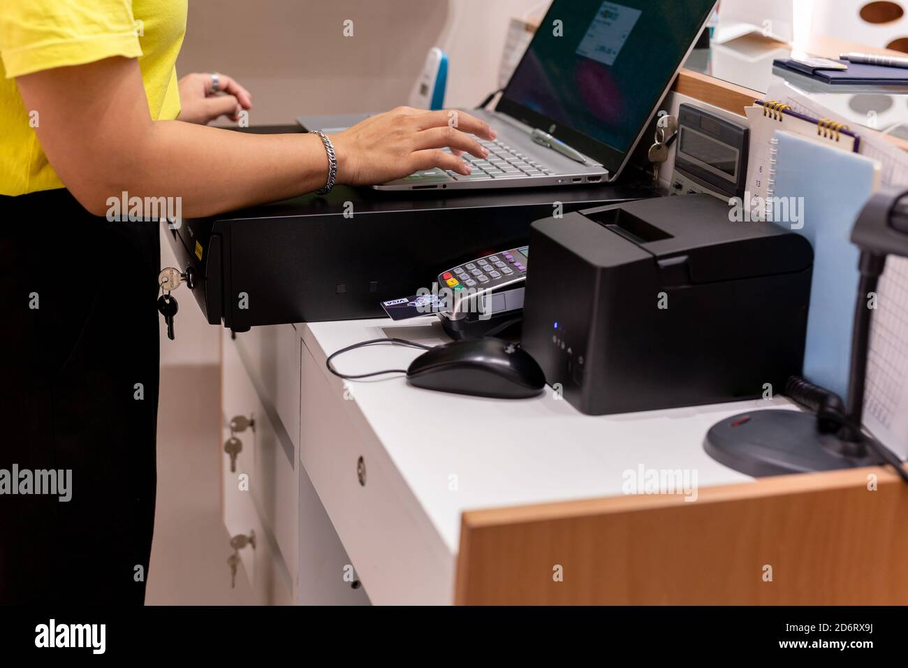 Hand typing keyboard on laptop with credit card in card reader at
