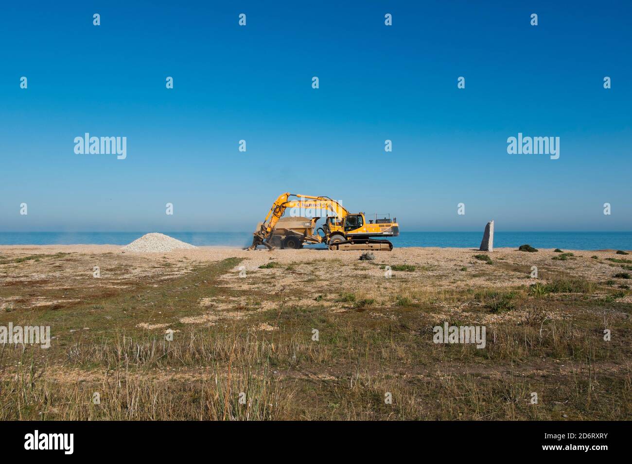 A Chunnel digger shifting the shingle up the beach to manage the effects of longshore drift at Kingsdown, Deal, Kent, UK Stock Photo