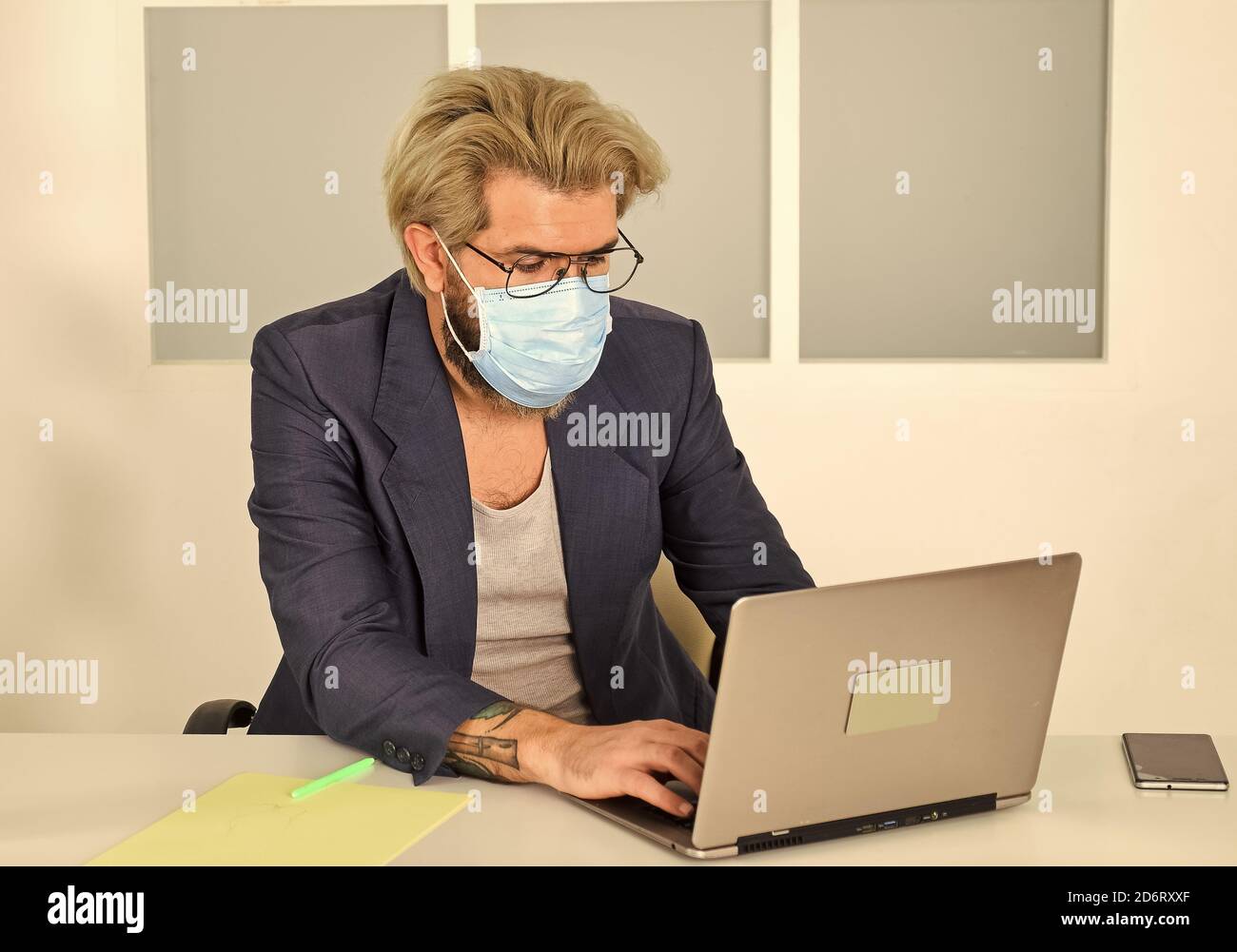 online shopping. man in respirator protective mask in office. work on a remote site. distance learning. infection control and prevention measures. keep your distance. remote-based job. Stock Photo