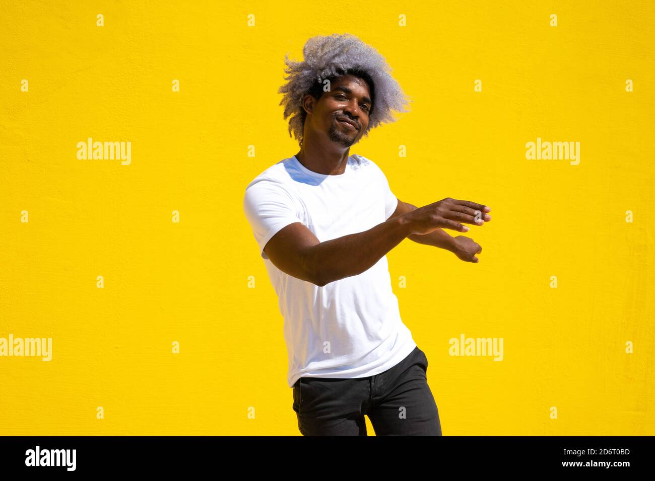 Afro black man dancer dancing on a yellow background. Dance and music