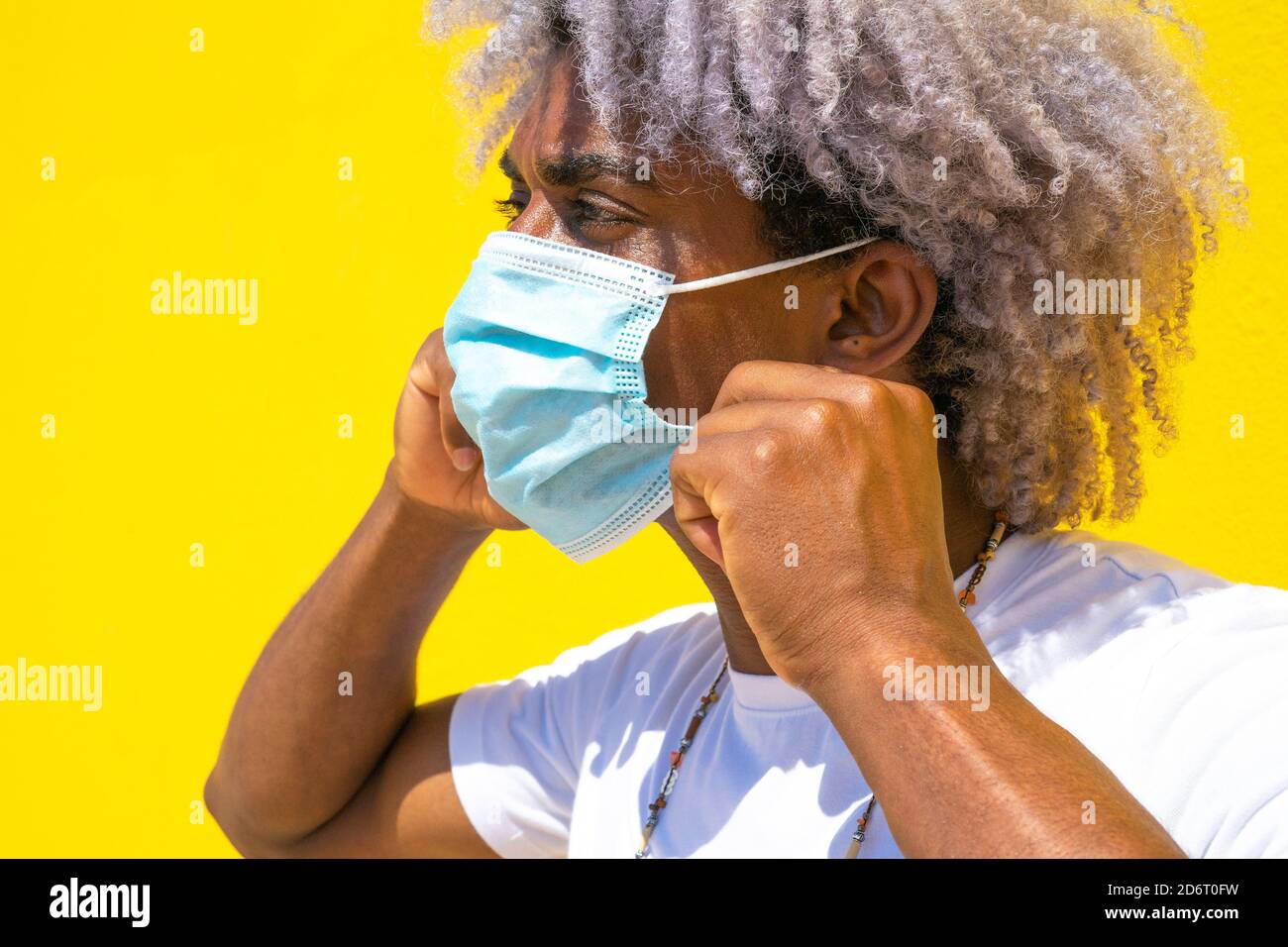 Black man with afro hair putting on mask. Black man with mask. COVID19