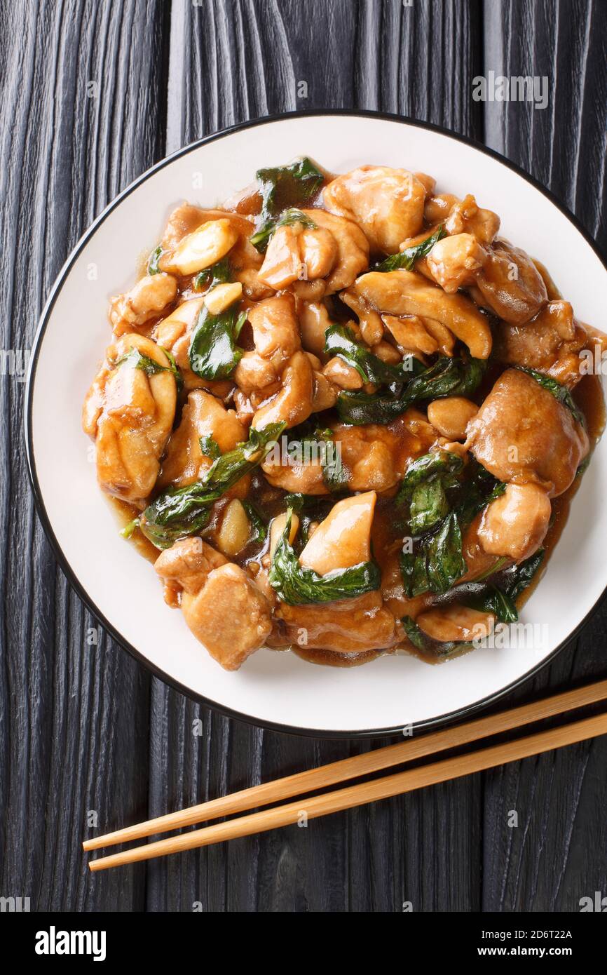 Sanbeiji is a popular chicken dish in Chinese cuisine closeup on the plate on the table. Vertical top view from above Stock Photo