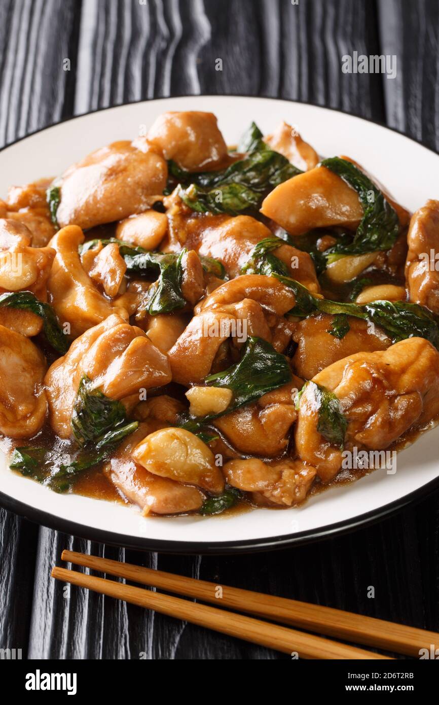 Sanbeiji is a popular chicken dish in Chinese cuisine closeup on the plate on the table. Vertical Stock Photo