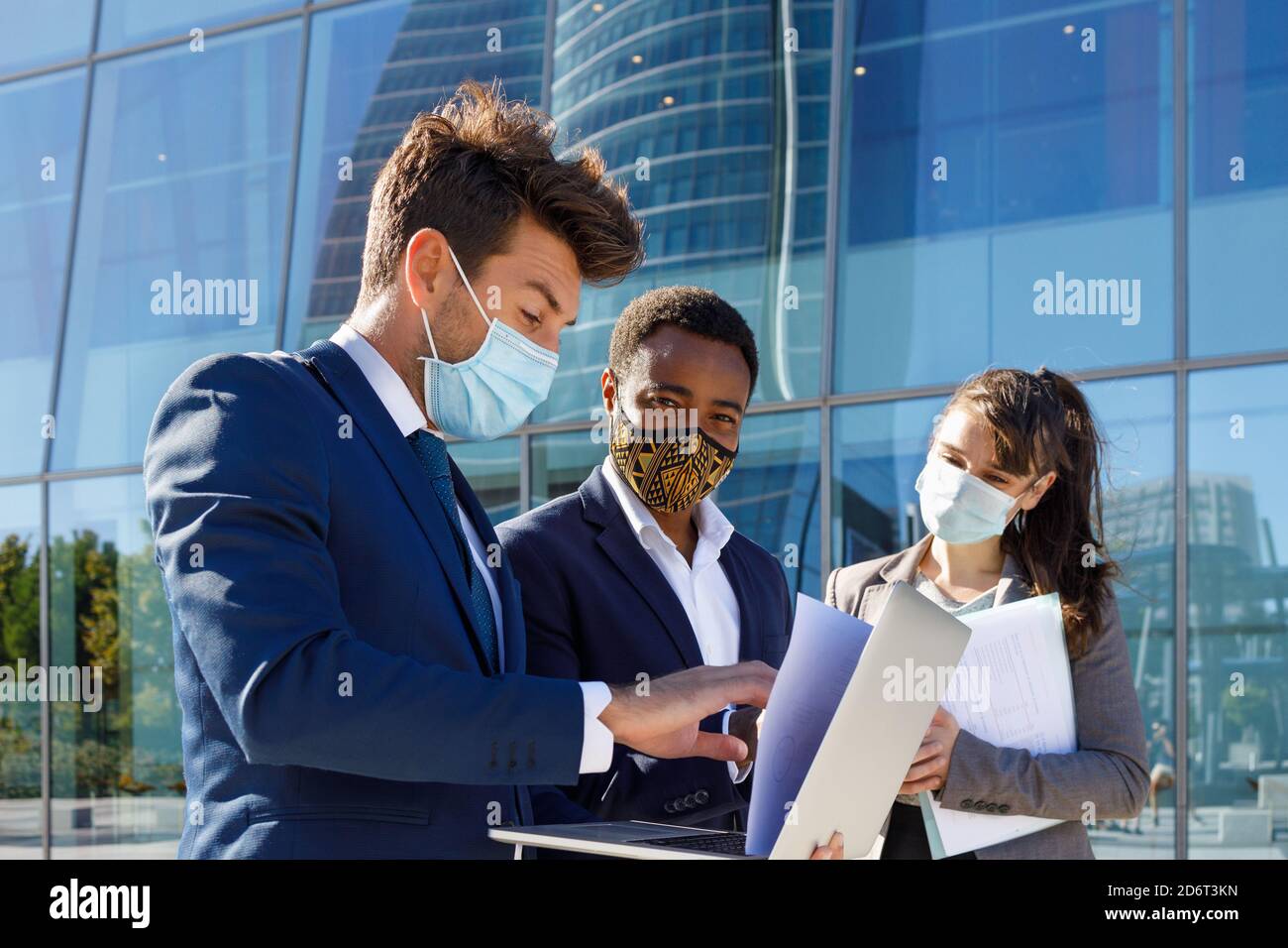 Crop of anonymous diverse coworkers working on laptop in formal suit ...