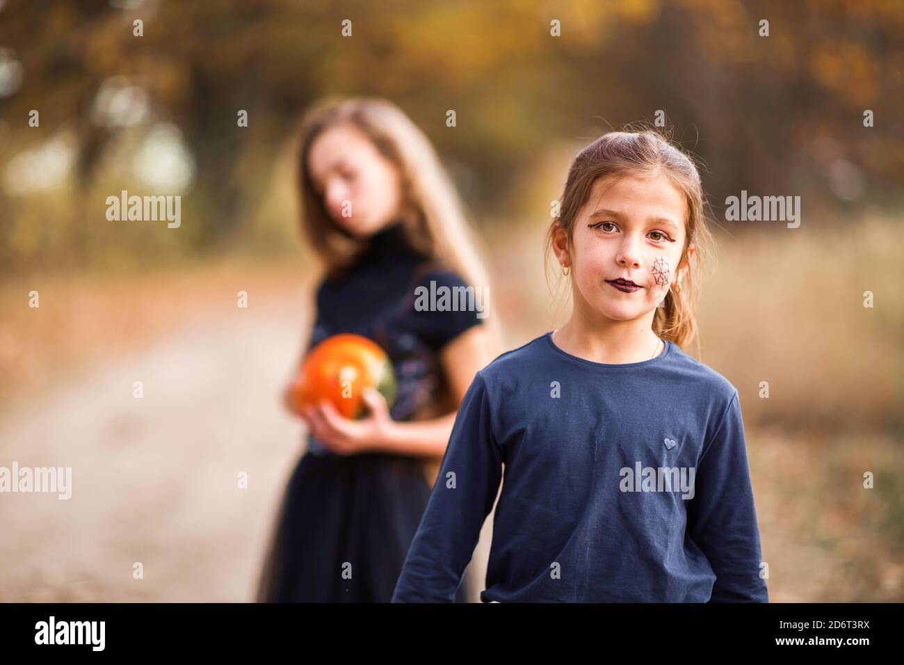 Two teenage girls prepare orange pumpkins for Halloween. Stock Photo