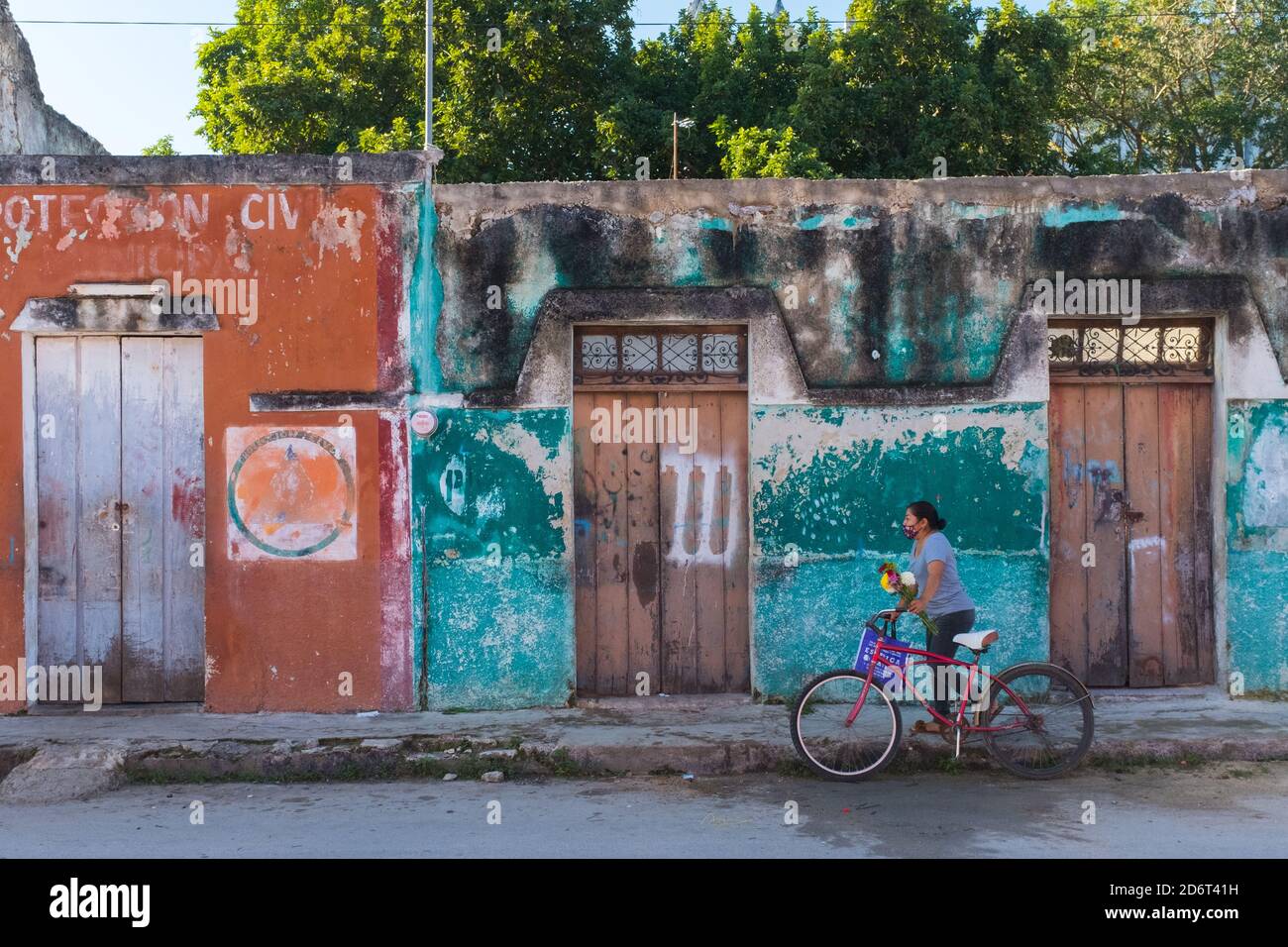 Woman walking with her bicycle in the little town of Dzemul Yucatan during the Covid-19 Pandemic . Yucatan Mexico Stock Photo