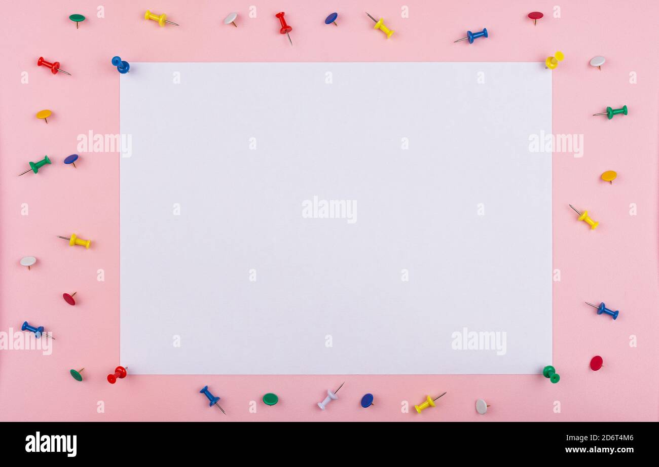 white sheet fastened with clerical multi-colored buttons on a pink background. Stock Photo