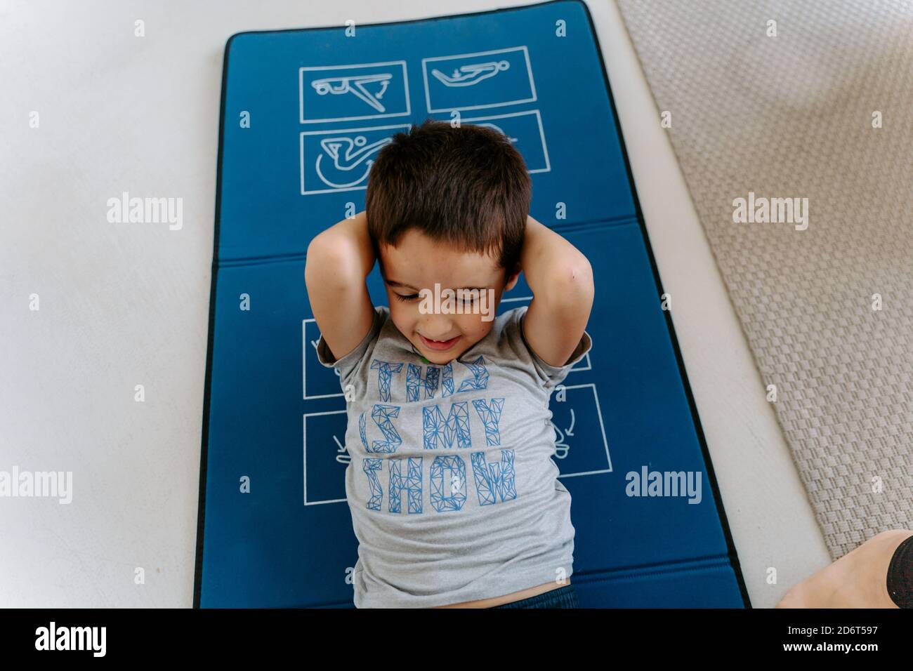 High angle positive little boy in sportswear with hands behind head