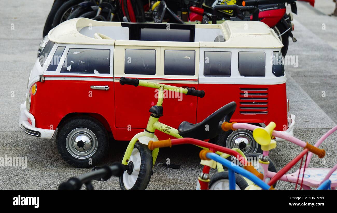 Electric toy vehicles and Bicycles aligned in a line for rent in a