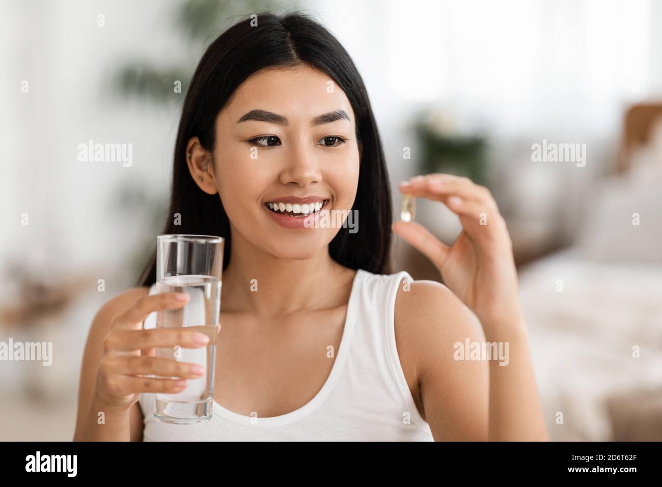 Happy Asian Woman Taking Pill In Morning Stock Photo