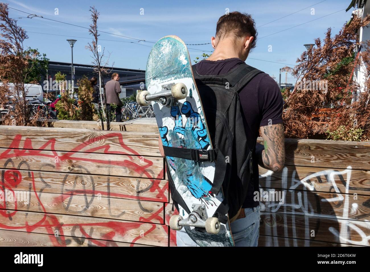 Berlin hipster trendy boy holding skateboard on shoulder Friedrichshain Berlin Germany young teenager rear Stock Photo