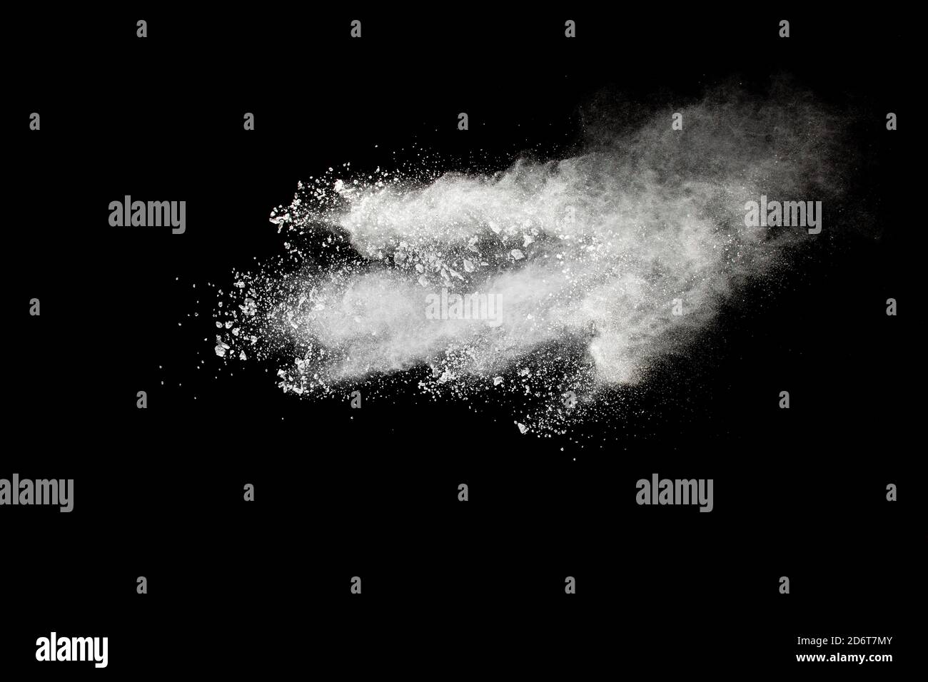 White powder explosion cloud against black background.White dust particles splash. Stock Photo