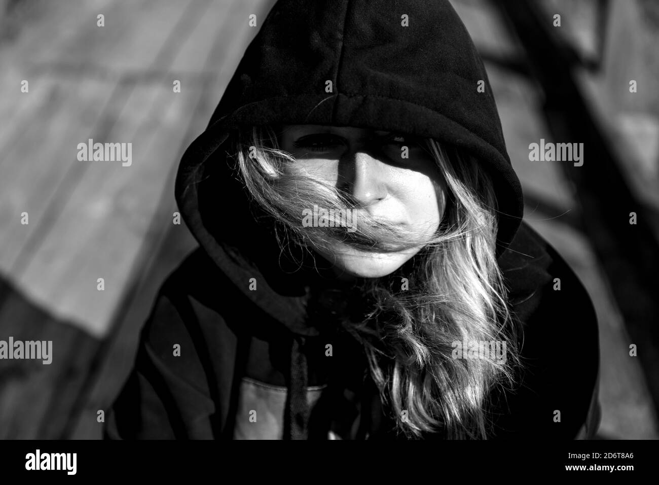Portrait of a teenage girl in a black hoodie outside. Stock Photo