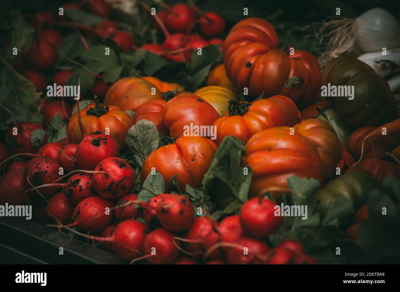 A pile of vegetables on a market stall. Beautiful ripe tomatoes and ...