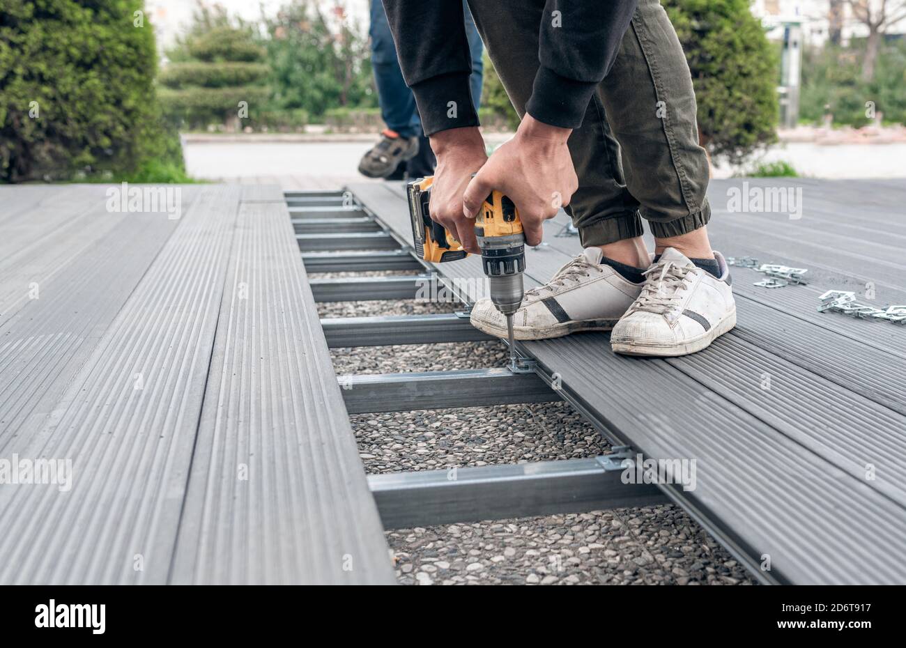 Man assembling composite deck using cordless screwdriver. Stock Photo