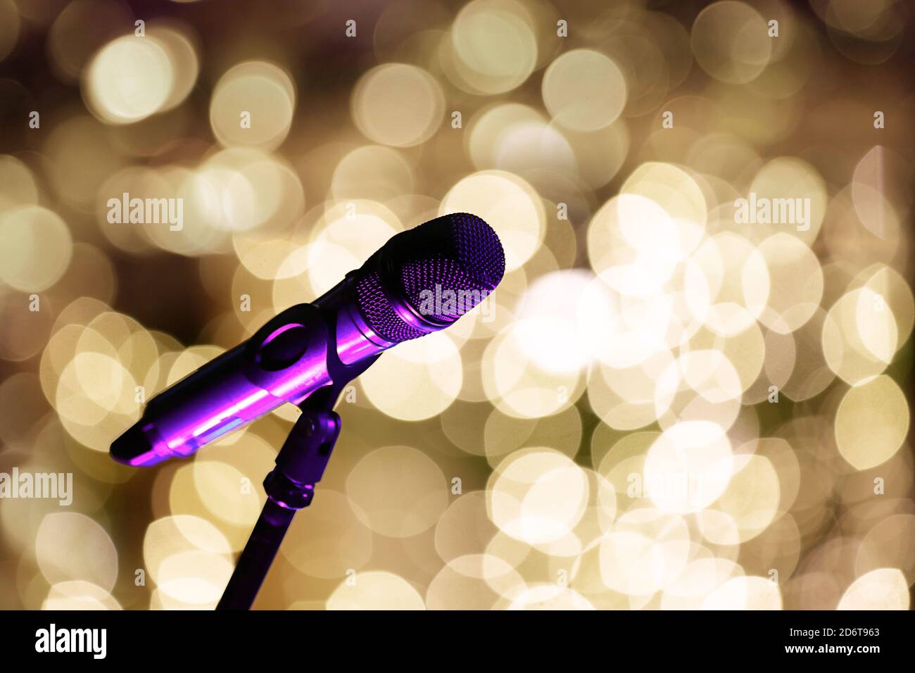 Microphone on stage in front of blurred lights and empty space for text Stock Photo