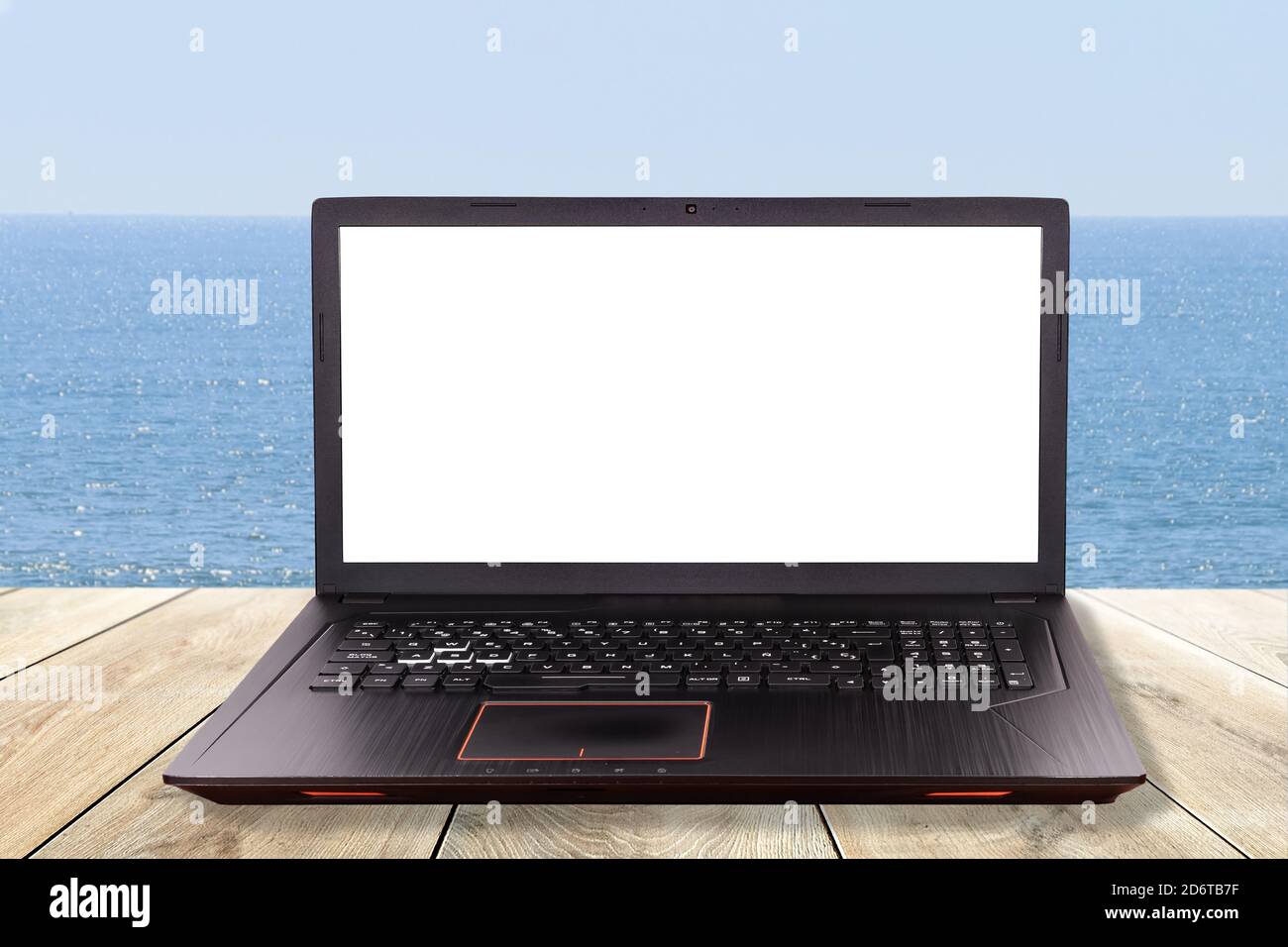 Black laptop over a table in the beach as concept for teleworking, telework ,telecommuting Stock Photo