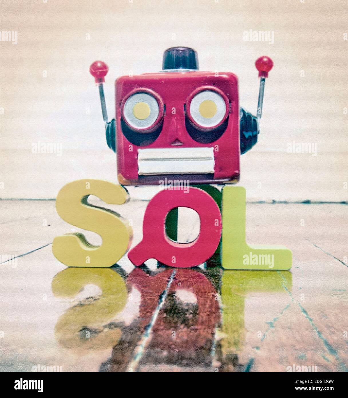 the acronym SQL with a robot head  on a wooden floor with reflection Stock Photo