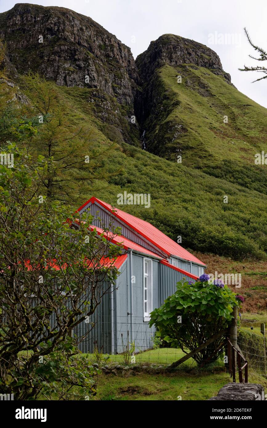 Lovely red roofed cottage nestling beneath the slopes of Beinn an Lochain with a great view of the Alltan na Sroine gulley. Stock Photo