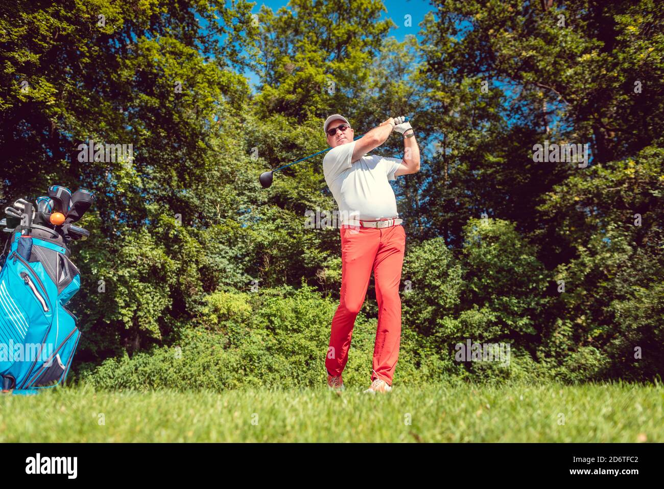 Golf player at the tee hitting ball far Stock Photo
