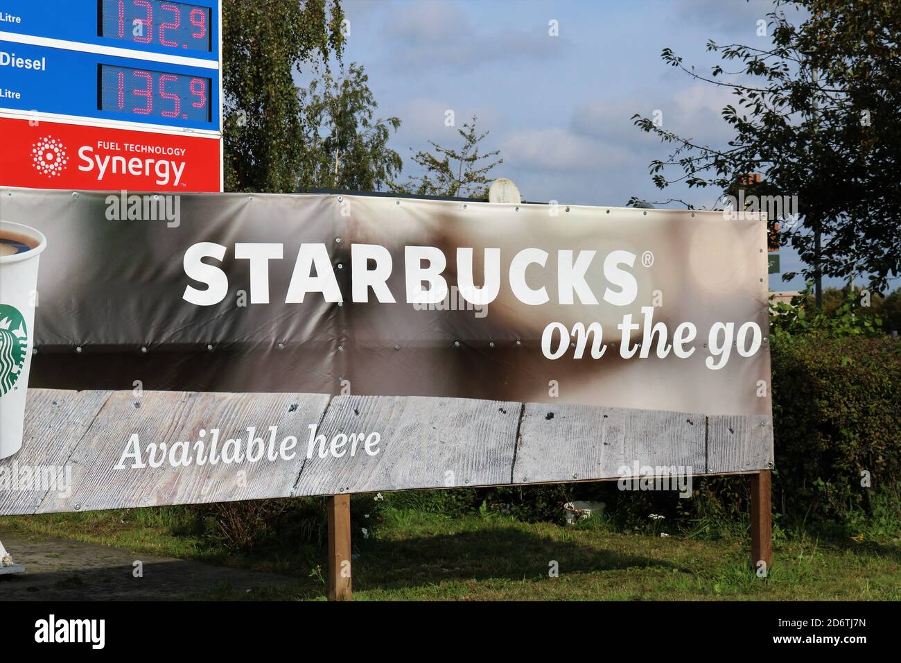Starbucks ....on the go sign banner at Esso petrol station. Stock Photo
