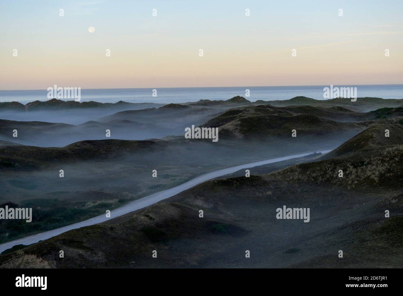 The Biville dunes along the coast of Normandy, on the Cotentin Peninsula. Overview of the stretch of sand of Biville at dusk, in the mist. The site is Stock Photo