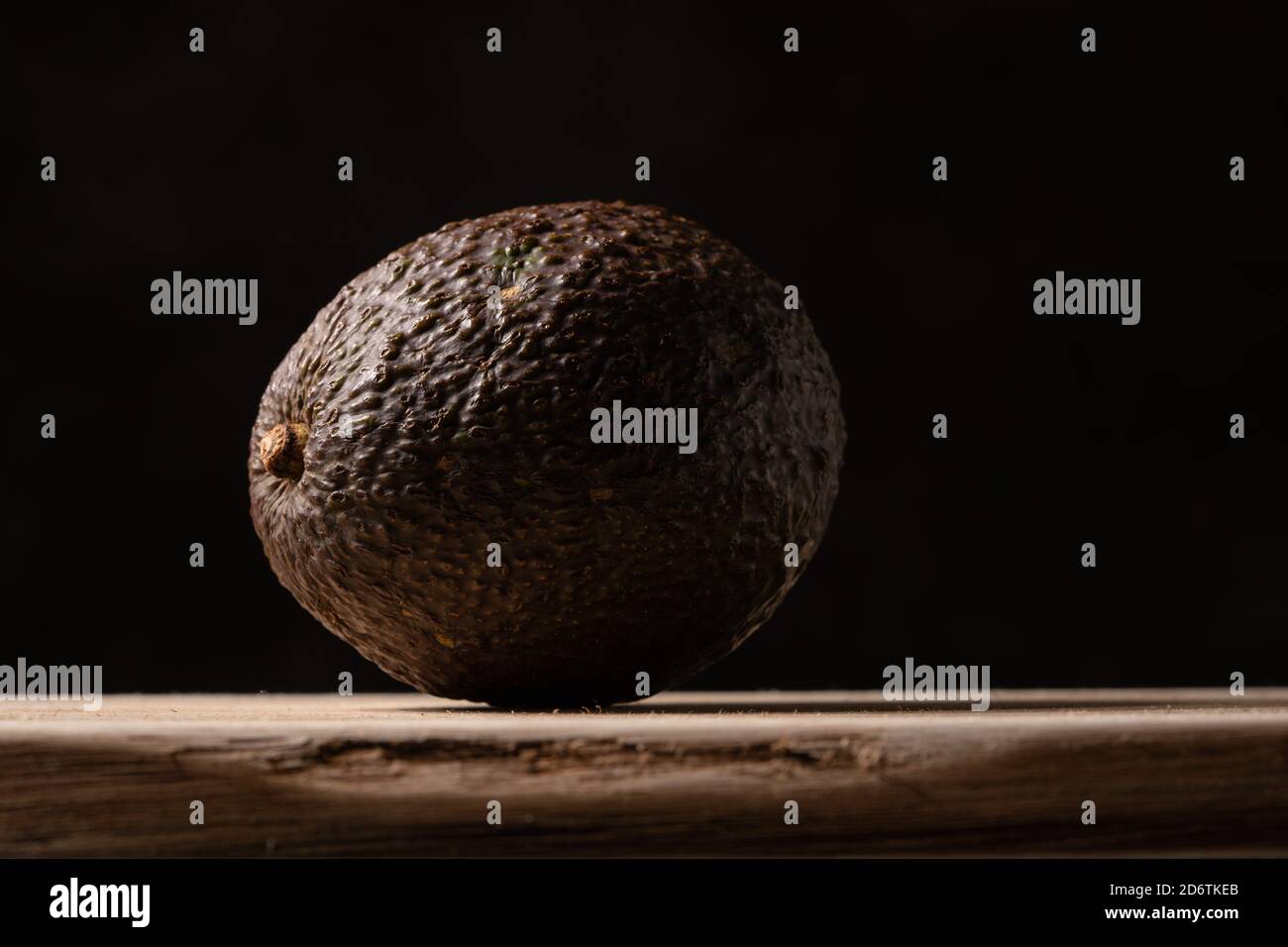 Fresh avocado on wooden board on black background. High quality photo Stock Photo