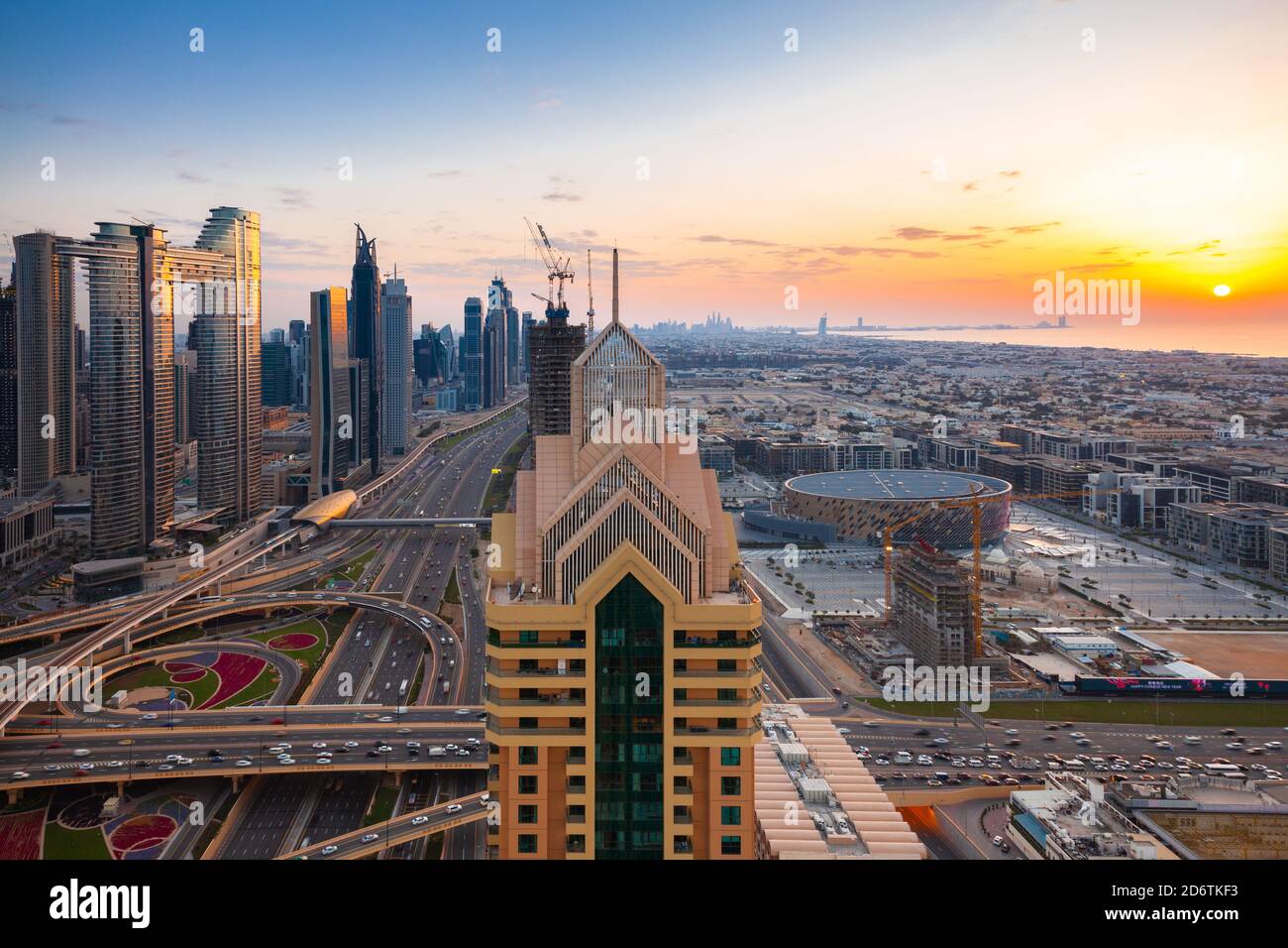 The view of Dubai skyline with Burj Khalifa, Sheikh Zayed road and sunset over the gulf, UAE. Stock Photo