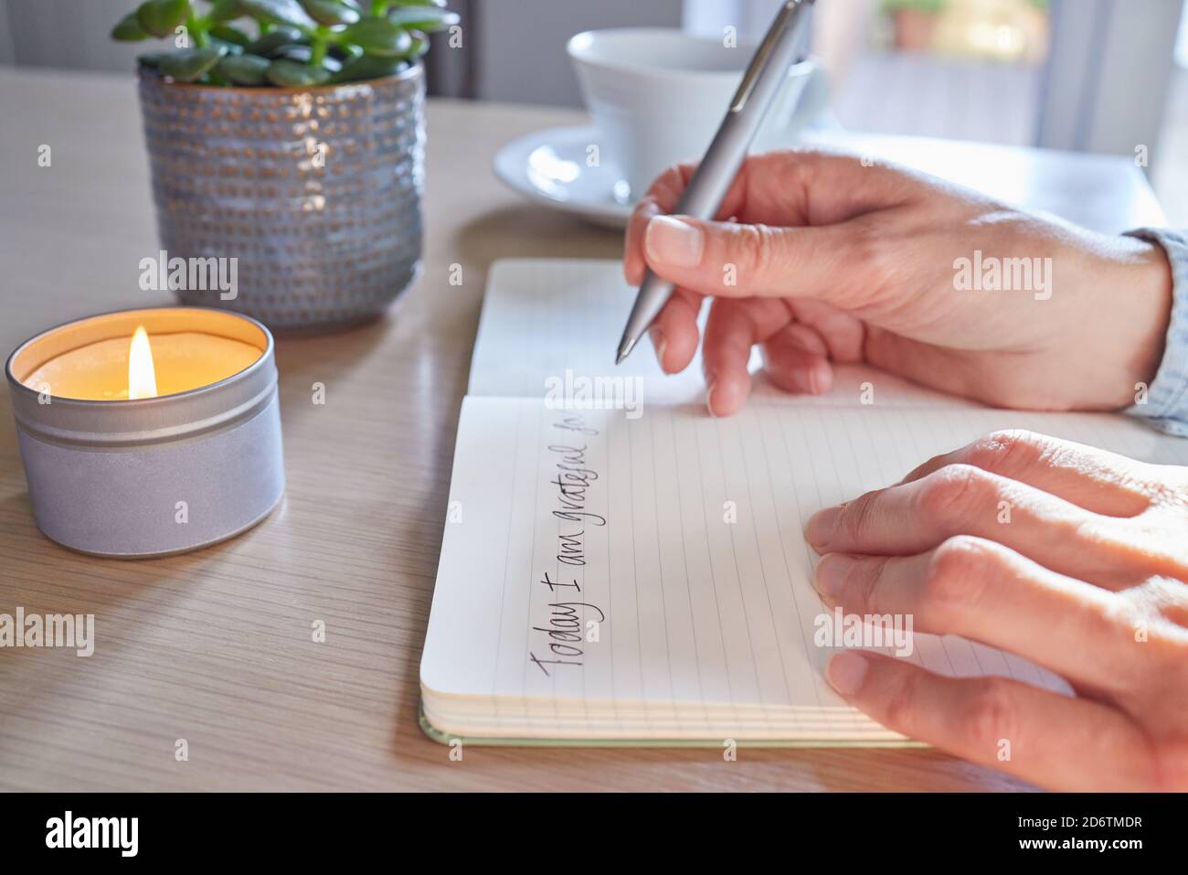 Close Up Of Woman At Home Writing In Gratitude Journal Stock Photo