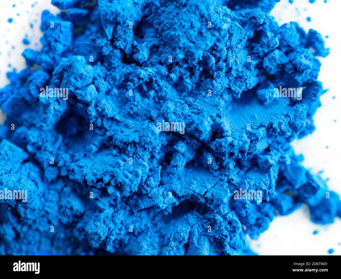 Closeup view of blue pigment. Pigment powder detail. Powders on white